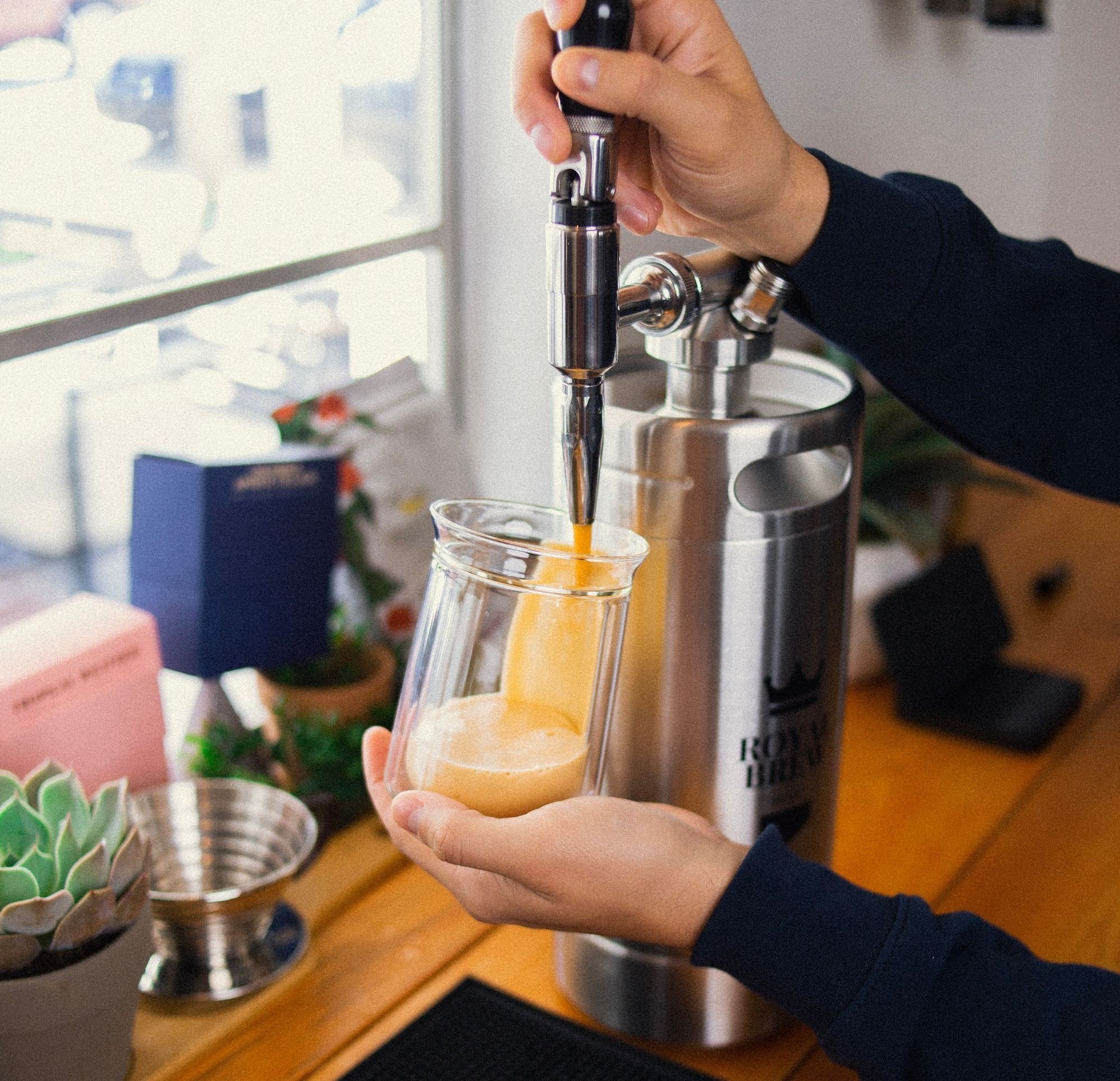 a person is pouring a drink into a glass